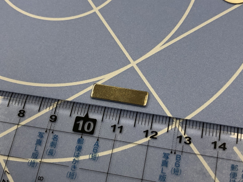 ネオジウム磁石のサイズを定規で測っている写真。長さは約１８ミリ。
