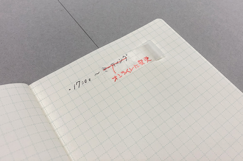 ノートに貼ったメンディングテープに文字を書いている写真